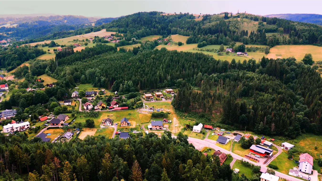 Panoramatický letecký pohled na lokalitu pozemků a okolní kopce