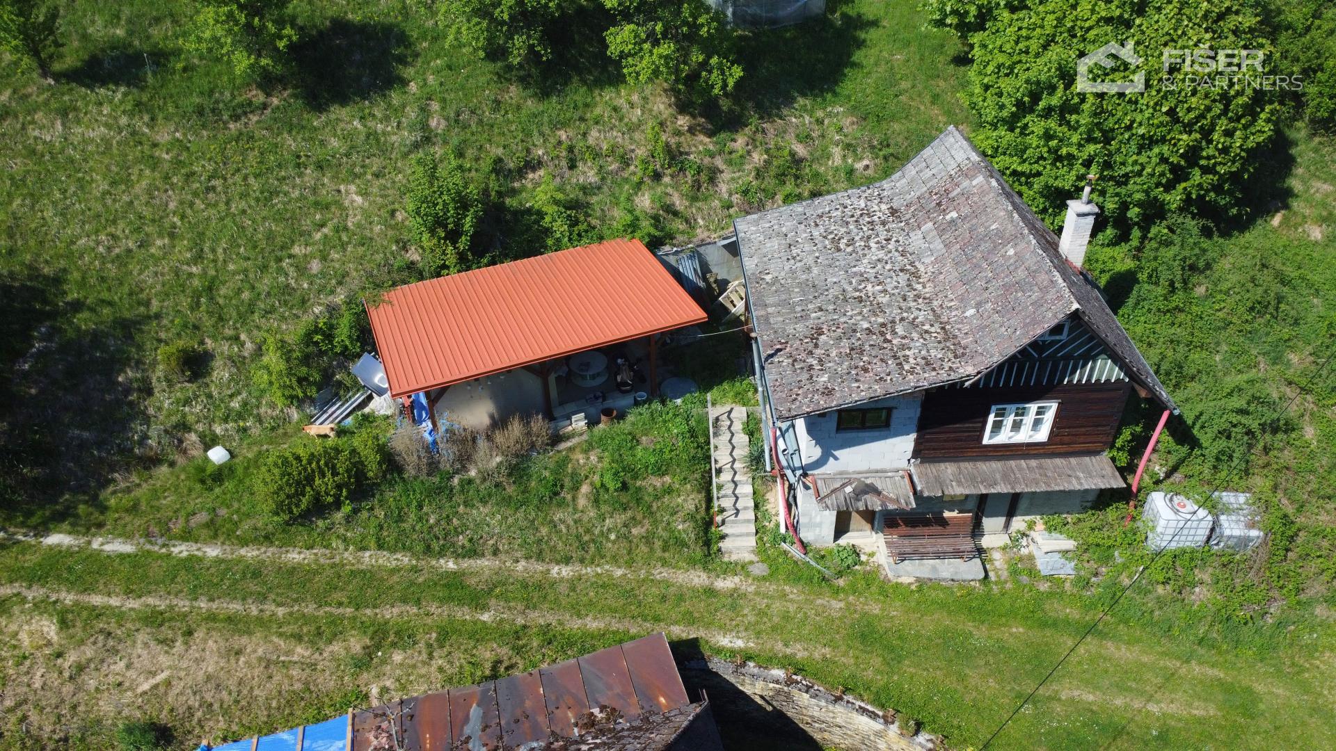 Letecký pohled na chatu, krytý přístřešek a okolní zahradu v Liptále
